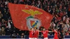 Benfica-Spieler klatschen vor den Rängen, während im Hintergrund eine riesige rote Vereinsflagge mit dem traditionellen Adler-Wappen geschwenkt wird.